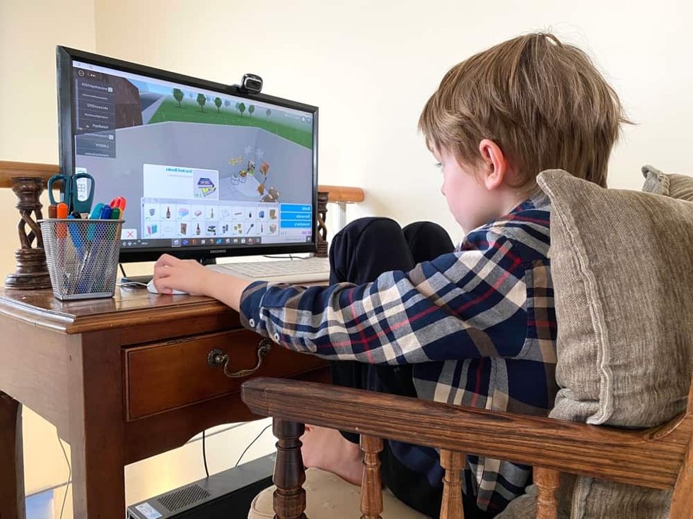 Young player building in a block-based game world